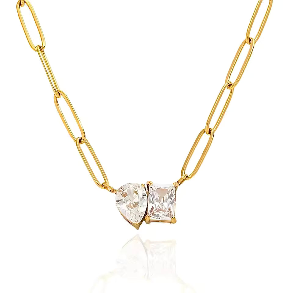 Paperclip gold chain with two large cubic zirconia's on white background 