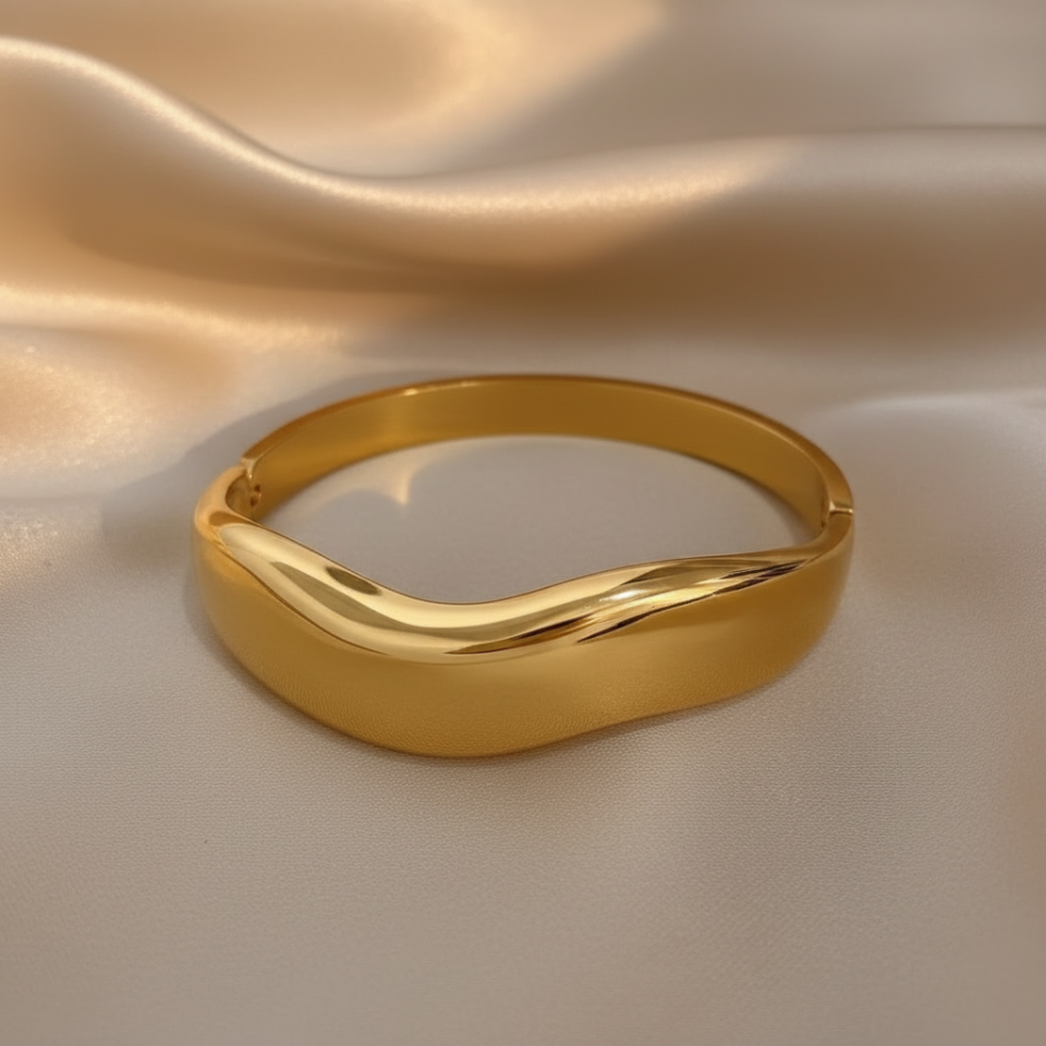 Gold cuff bracelet with wave design with satin background