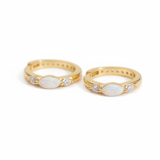 Two gold earrings with white stones on a white background