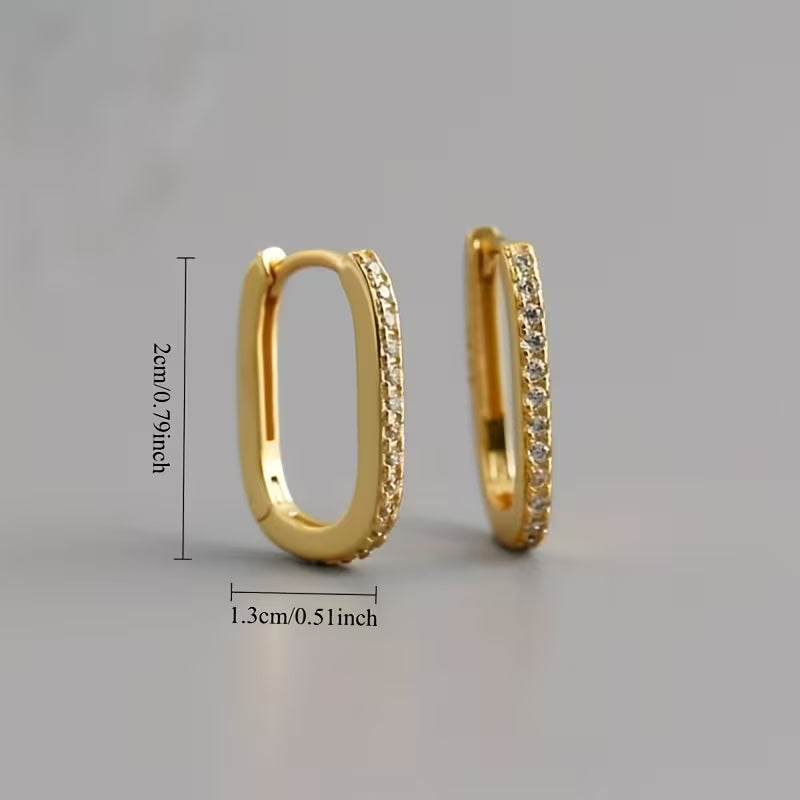 Gold hoop earrings with diamond accents on a gray background, showing measurements.