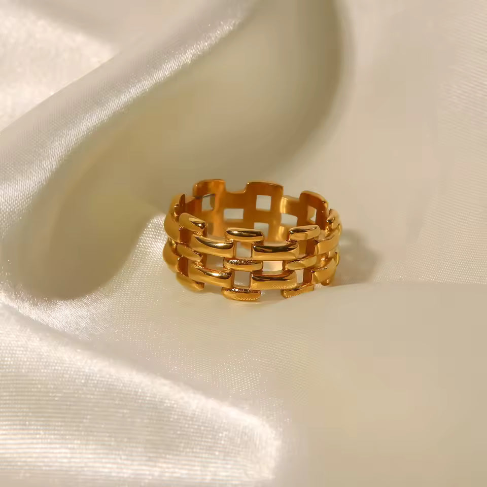 Gold woven ring on a satin surface