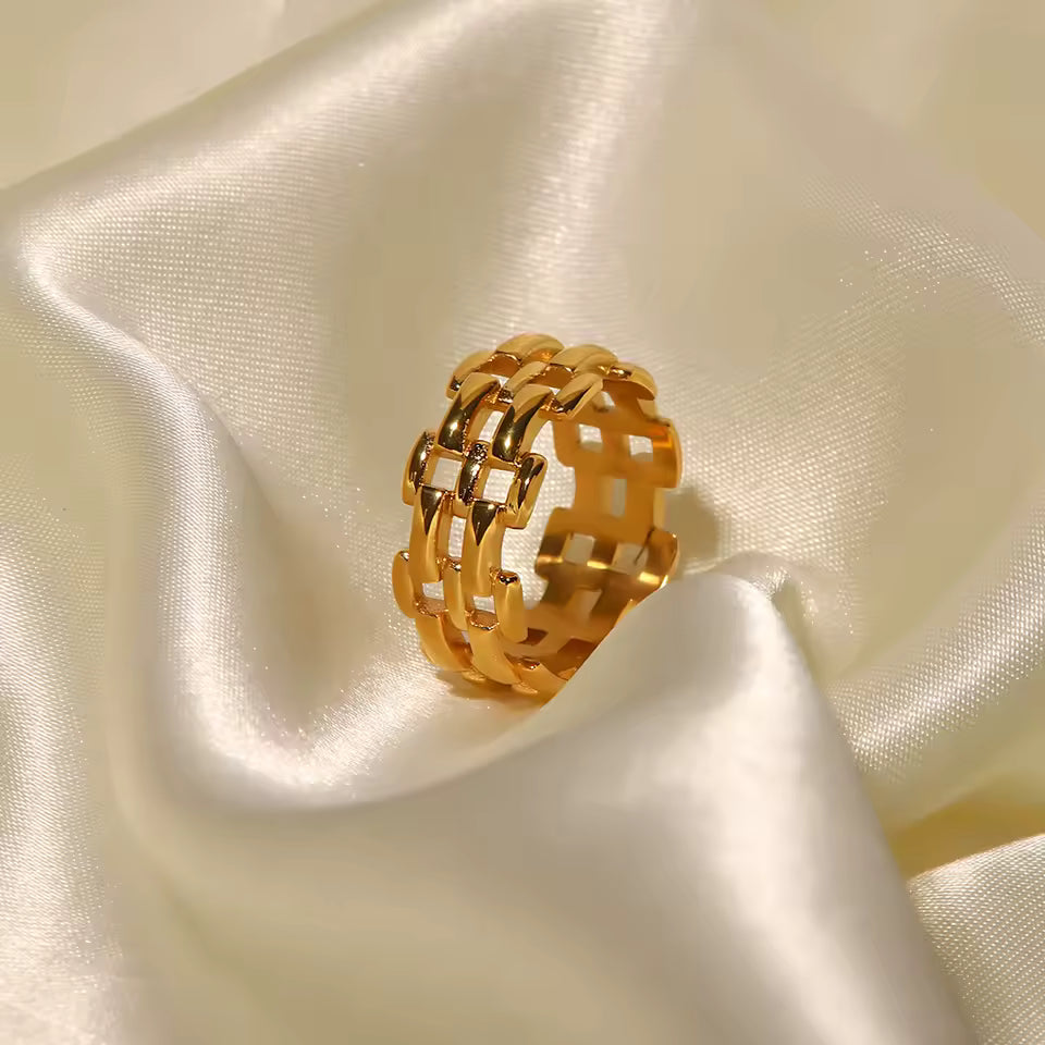 Gold chain ring on a textured beige fabric background