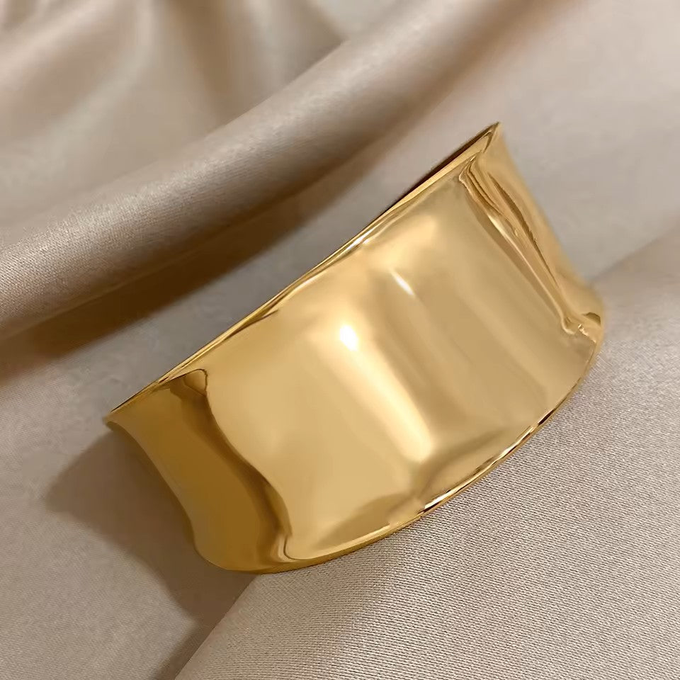 Gold bracelet on a beige fabric background