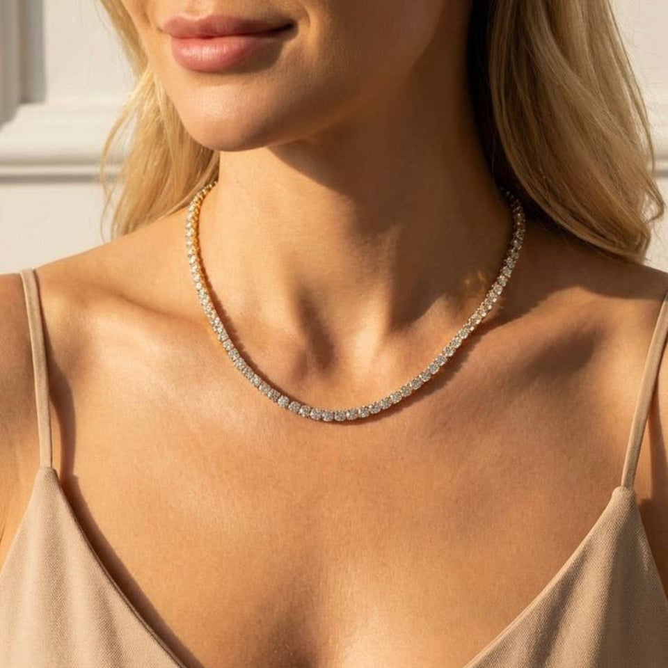 Close-up of a woman wearing a delicate necklace with a neutral background