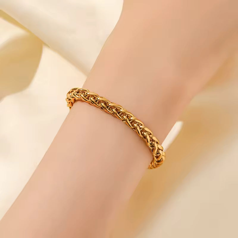Gold bracelet on a wrist with a soft beige background