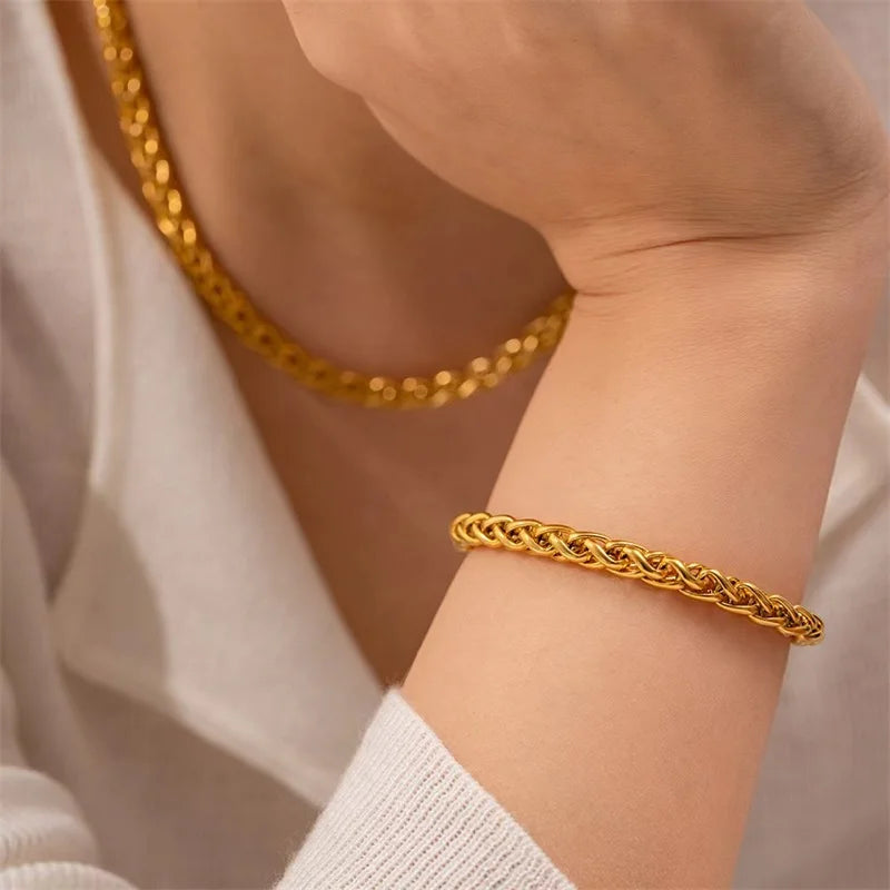 Gold chain bracelet on a wrist with a blurred background