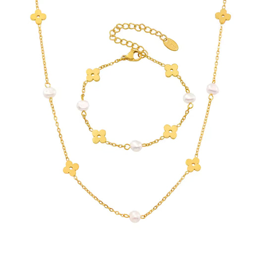 Gold necklace with floral and pearl details on a white background
