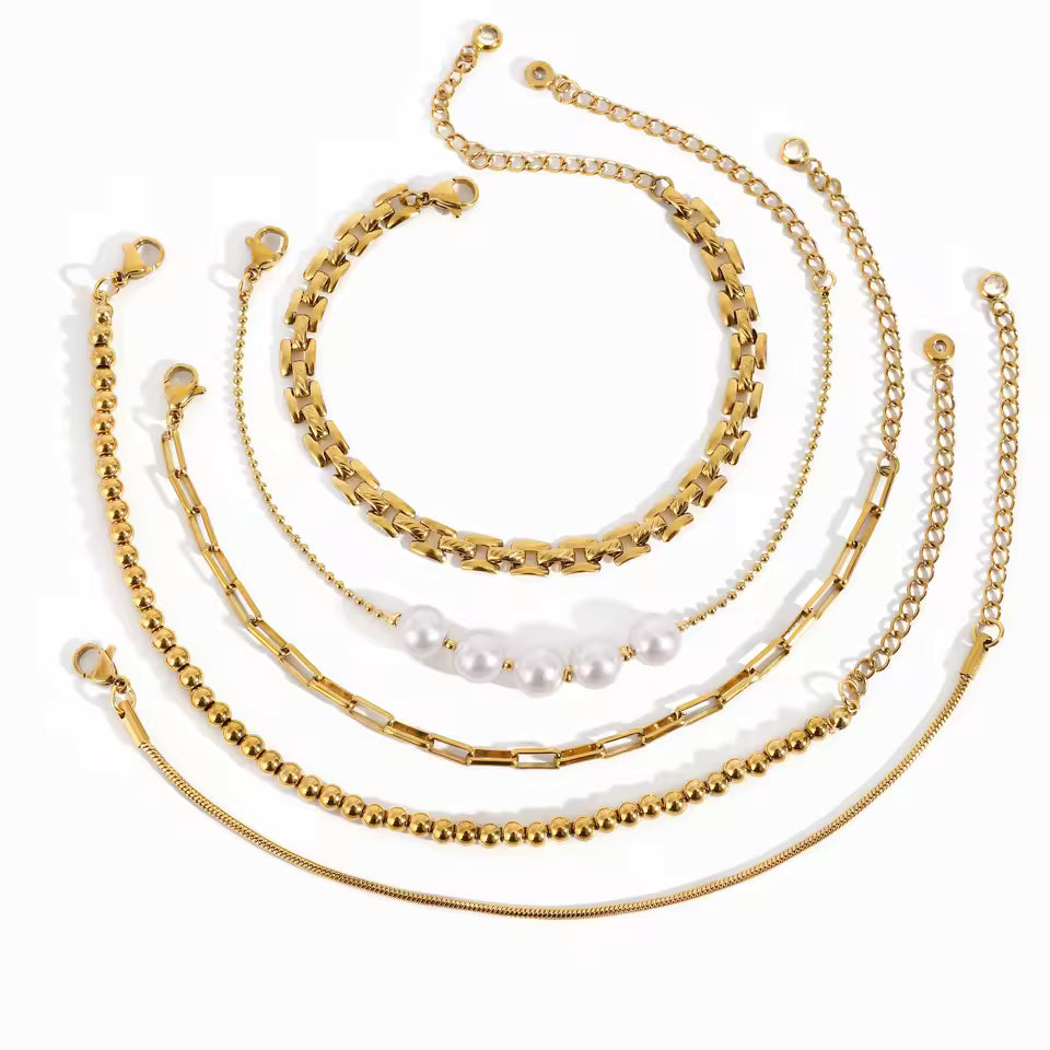 Set of gold bracelets with various designs on a white background