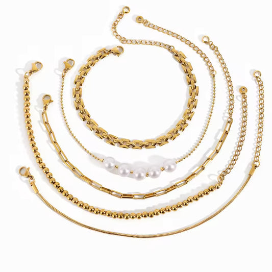 Set of gold bracelets with various designs on a white background