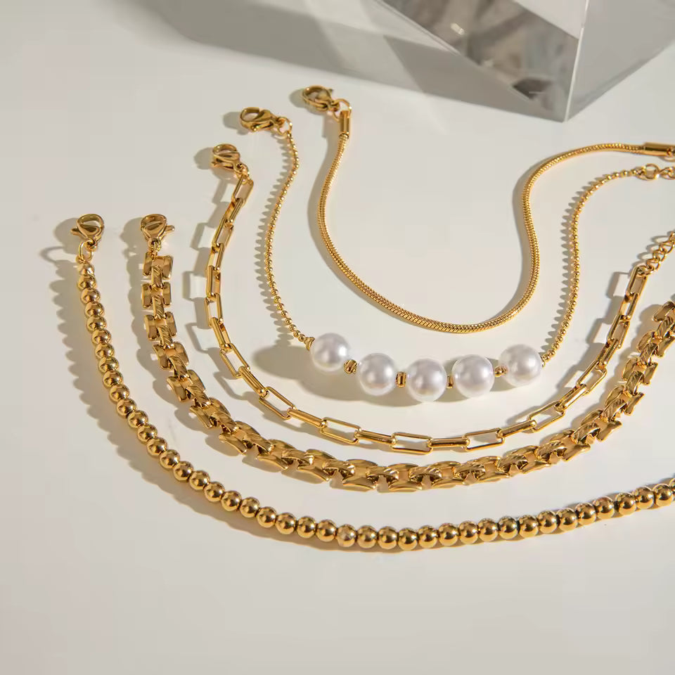 Gold bracelets with various designs on a light background