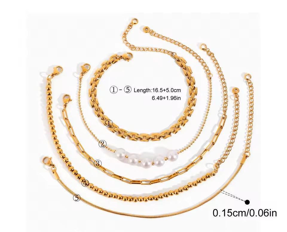 Set of gold chain bracelets with pearls on a white background