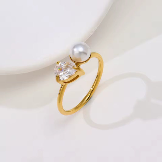 Ring with pearl and diamond setting on plain background