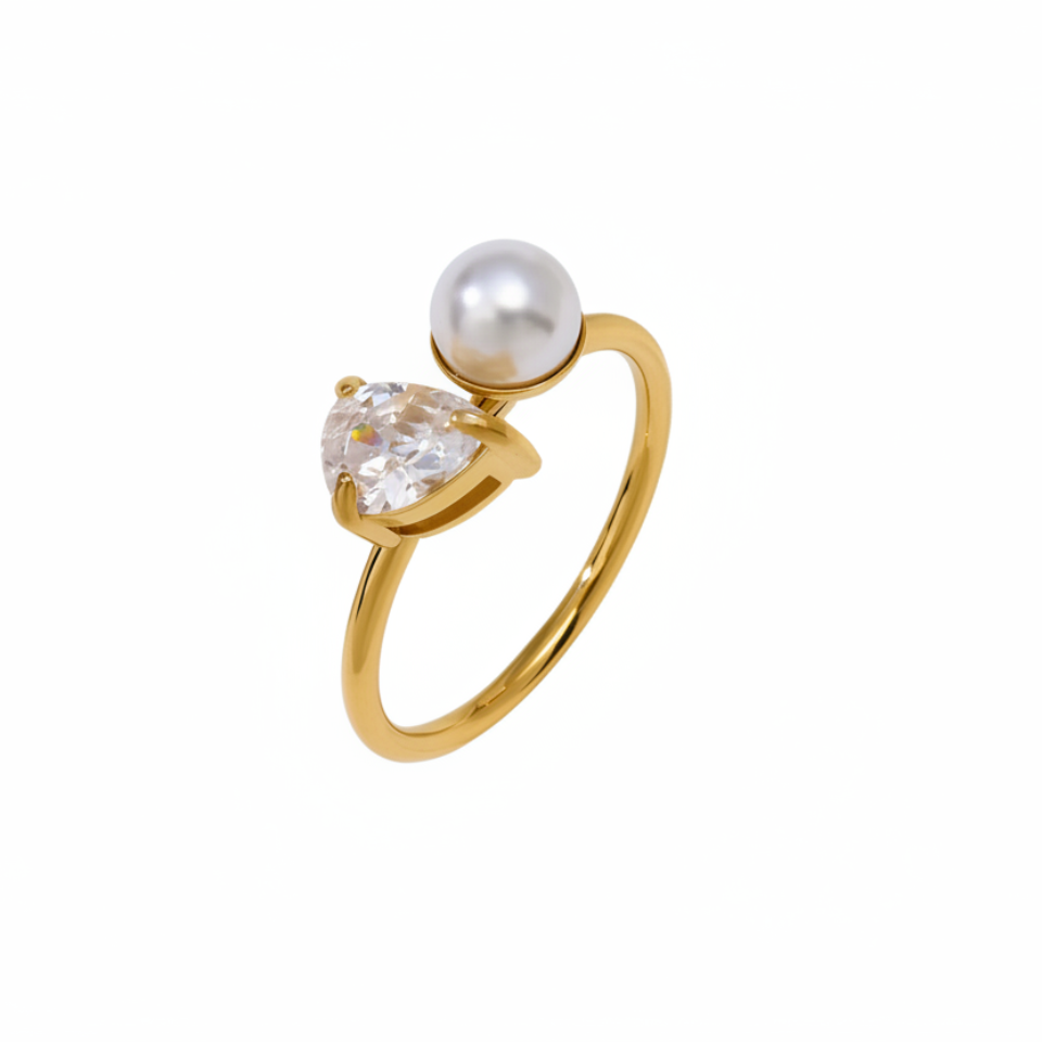 Gold ring with a heart-shaped diamond and pearl on a white background