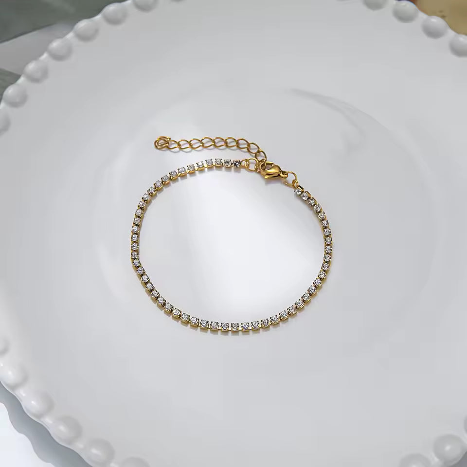 Gold bracelet with diamonds on a white plate