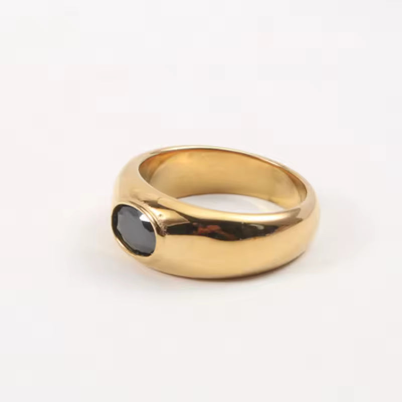 Gold ring with a black gemstone on a white background