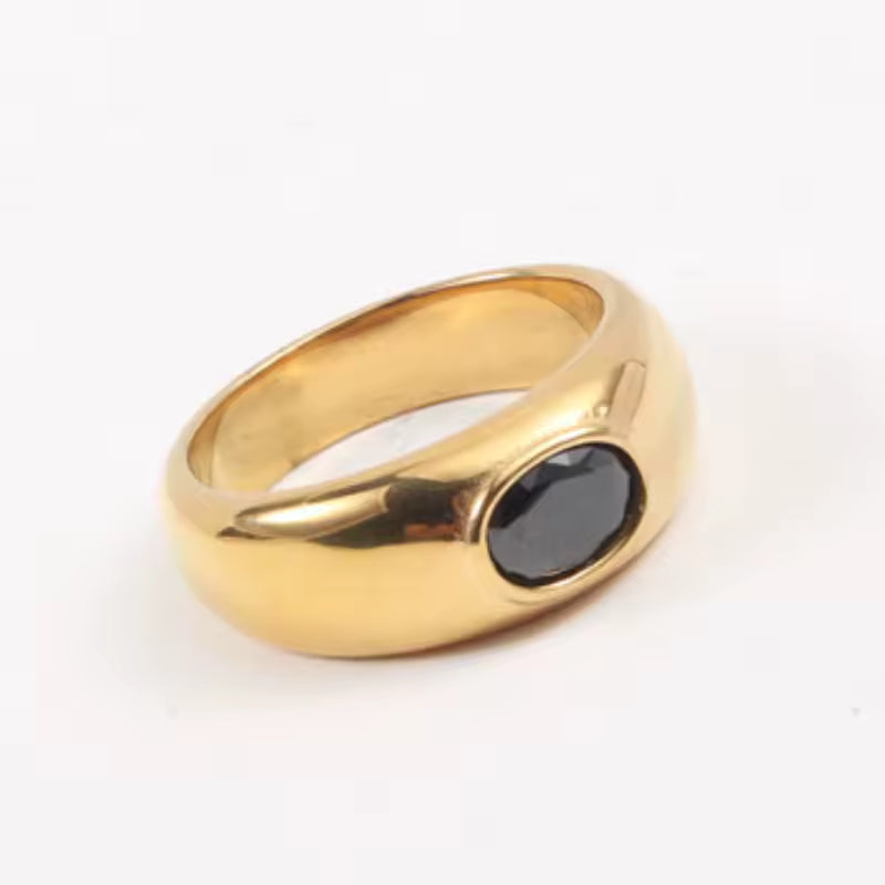 Gold ring with a black gemstone on a white background