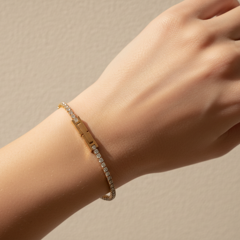 Gold bracelet on a wrist against a beige background