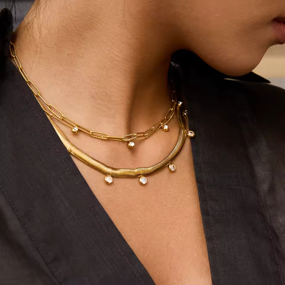 Close-up of a person wearing gold necklaces with a blurred background