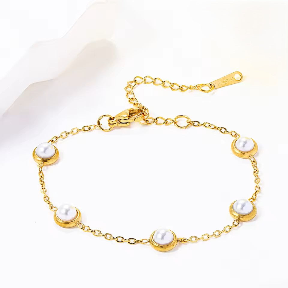 Gold bracelet with pearls on a white background