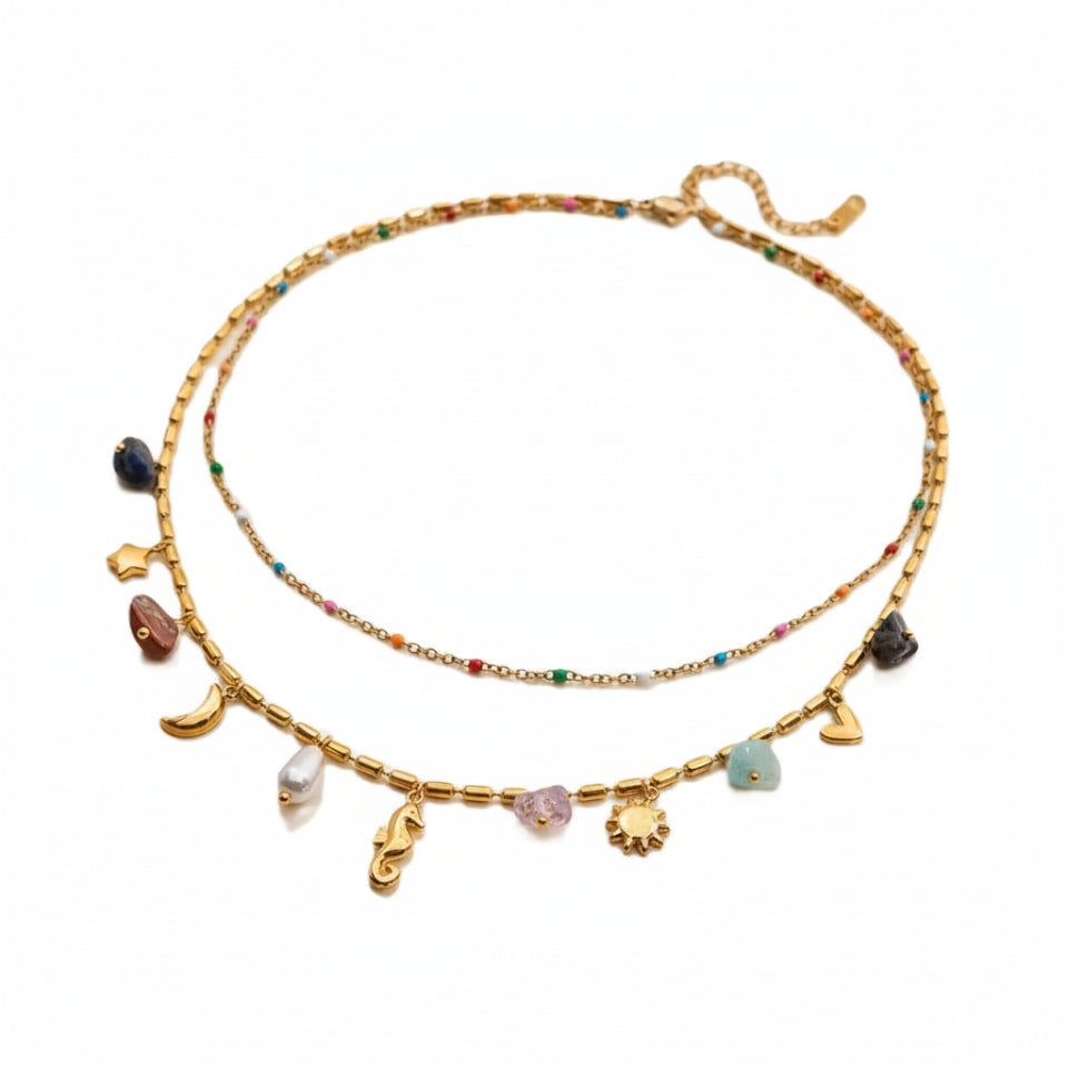 Gold necklace with various charms on a white background