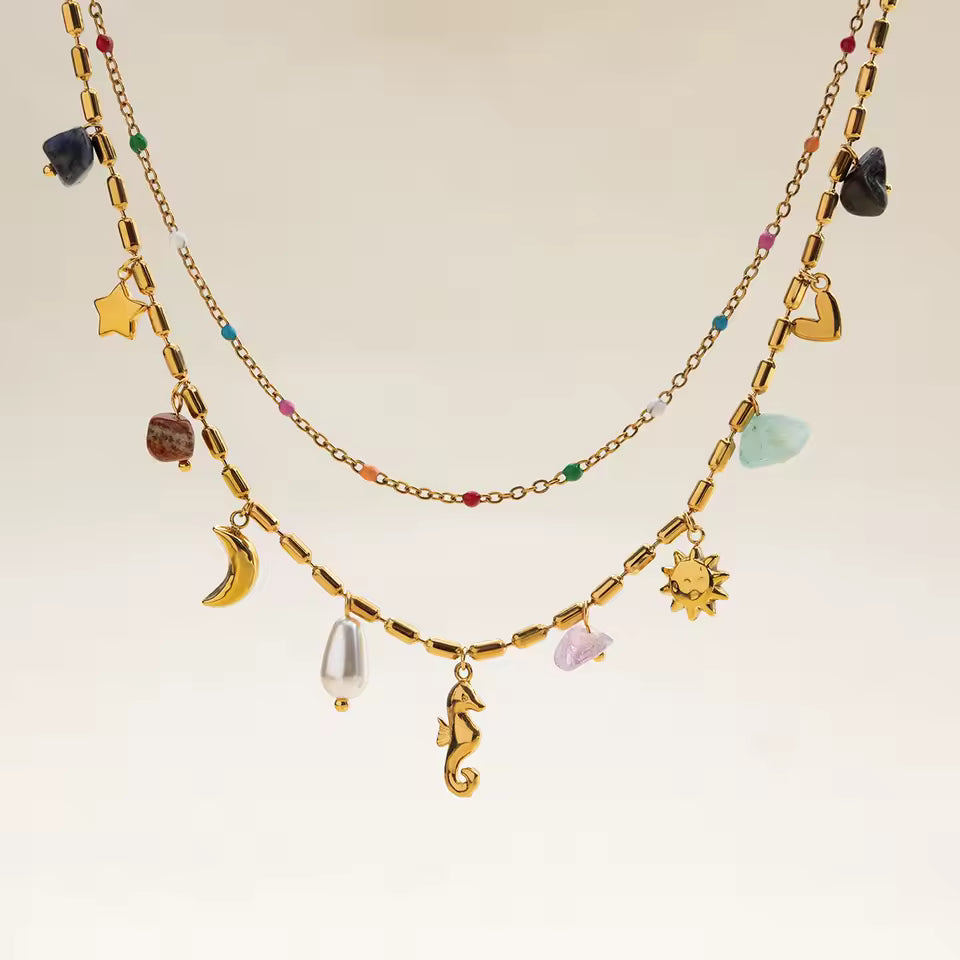 Gold necklace with various charms on a beige background