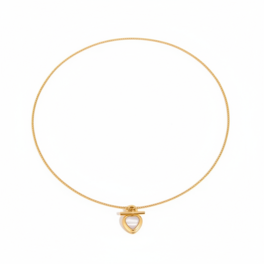 Gold necklace with a heart-shaped pendant on a white background
