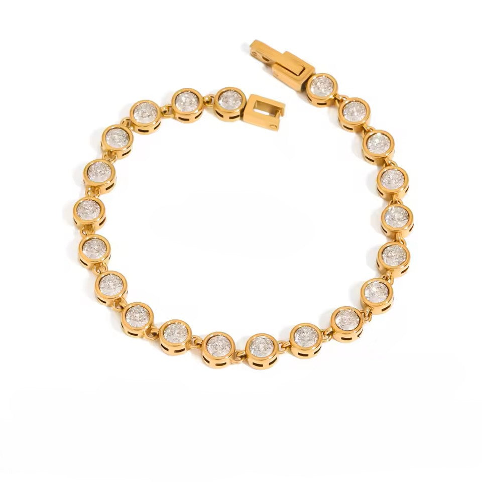 Gold bracelet with clear gemstones on a white background
