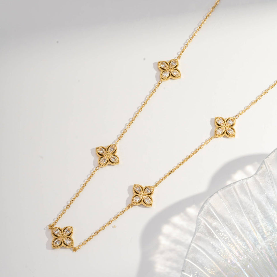 Gold necklace with floral pendants on a white background