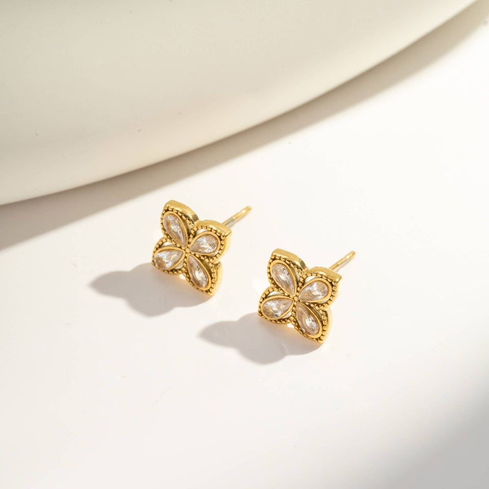 Gold butterfly earrings on a light background