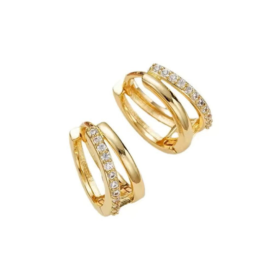 Pair of gold hoop earrings with clear gemstones on a white background