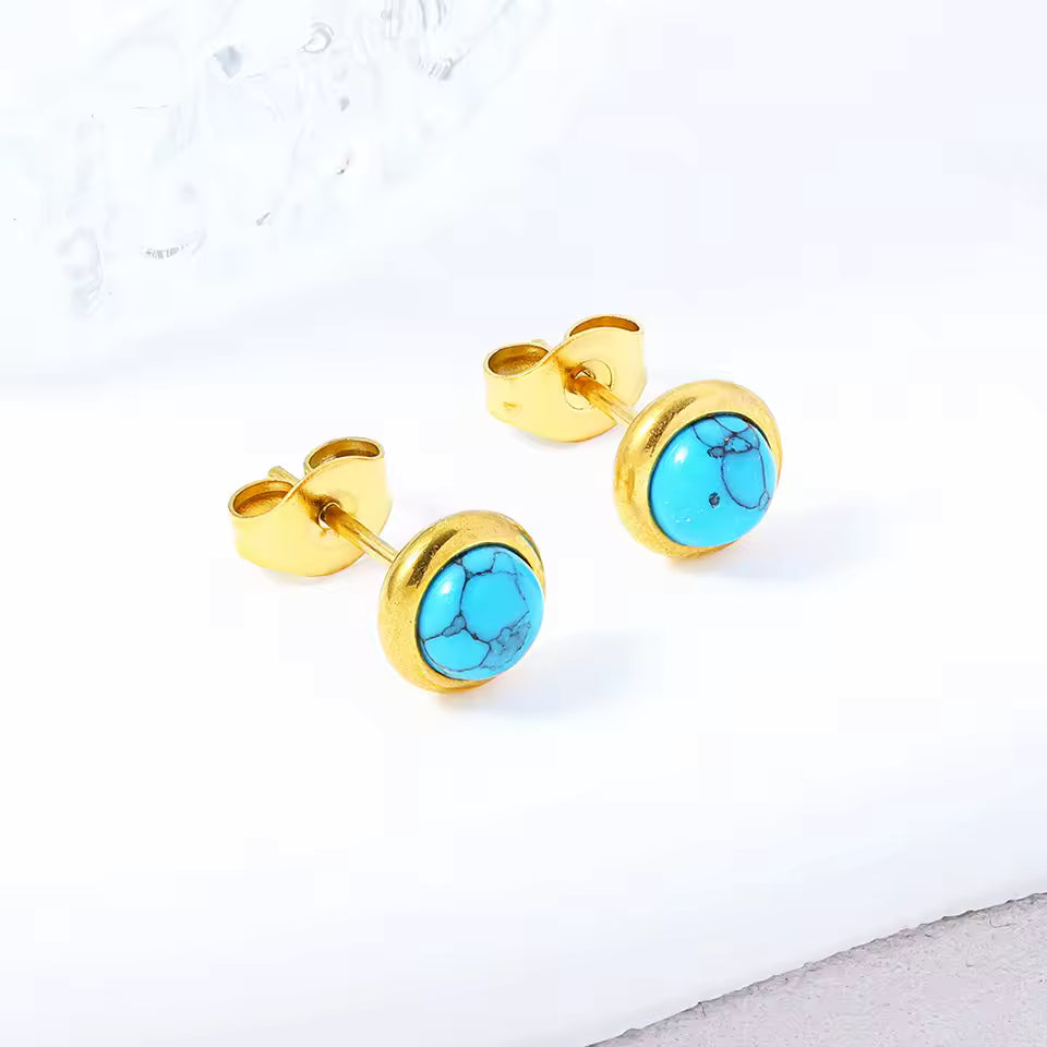 Gold earrings with turquoise stones on a white background