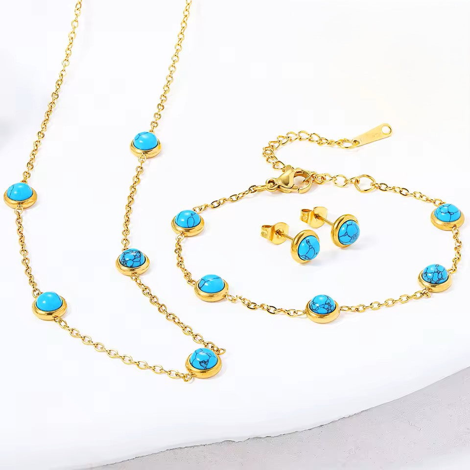 Gold jewelry set with turquoise stones on a white background