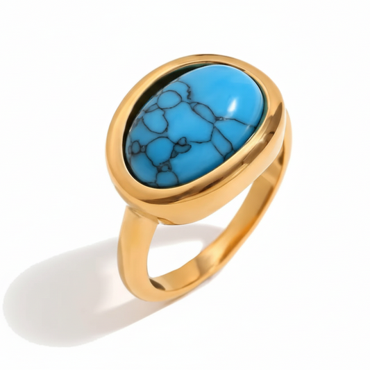 Gold ring with a turquoise stone on a white background