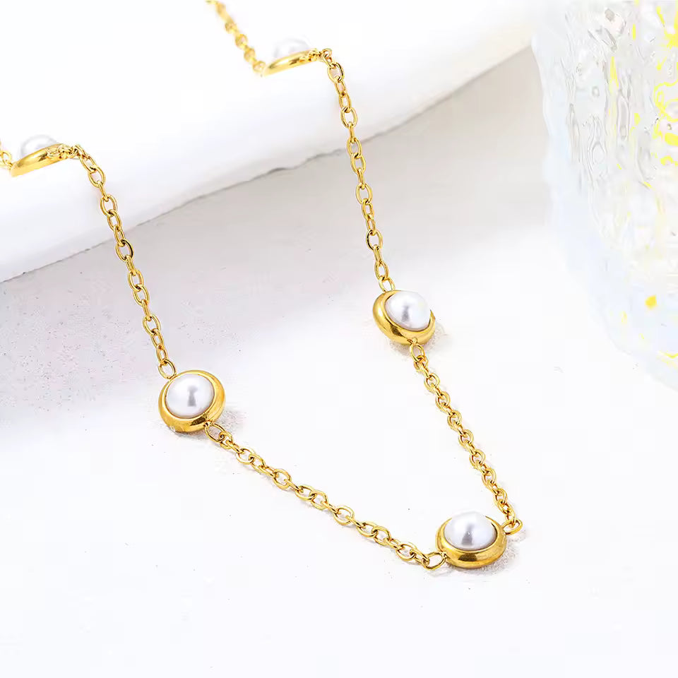 Gold necklace with pearls on a white background
