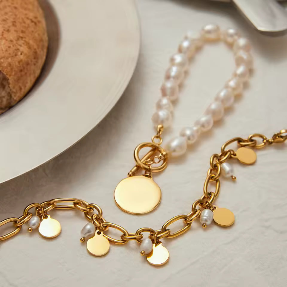 Gold charm bracelet with pearls on a neutral background