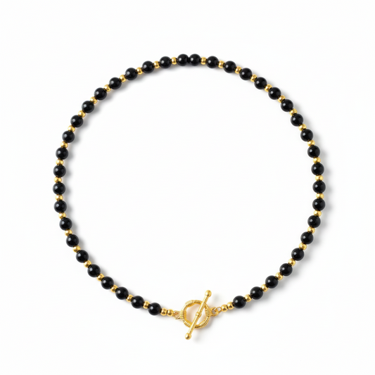 Black beaded necklace with a gold clasp on a white background